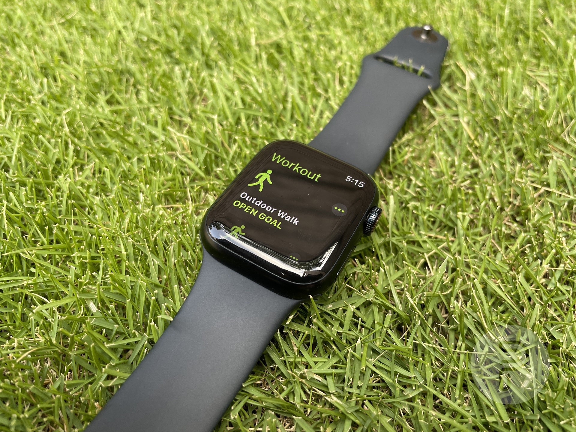 montre apple placée sur la pelouse avec entraînement de marche en plein air à l'écran
